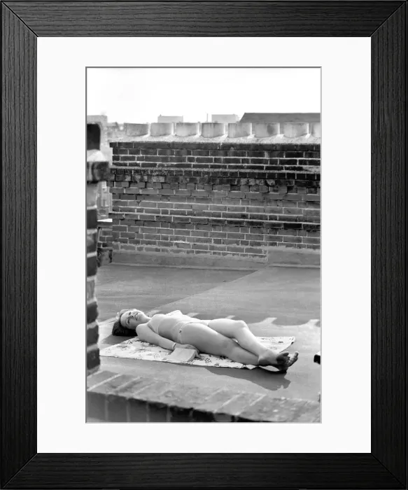 Framed Print : A model wearing a bikini as she subathes on a rooftop on Kings Road in Chelsea, London Framed Print : A model wearing a bikini as she subathes on a rooftop on Kings Road in Chelsea, London