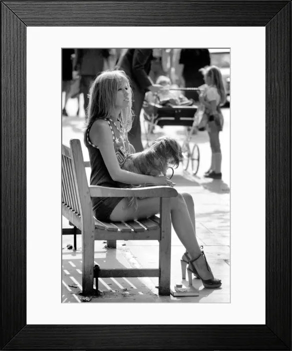 Framed Print : Woman taking her dog for a walk on Kings Road in Chelsea, sitting down on a bench Framed Print : Woman taking her dog for a walk on Kings Road in Chelsea, sitting down on a bench