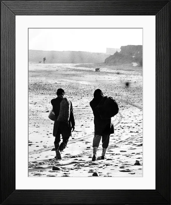 Framed Print : Two men make their way along a beach with their sacks of sea coal that they have Framed Print : Two men make their way along a beach with their sacks of sea coal that they have