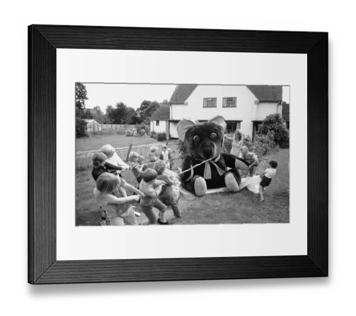 Framed Print : Children from the village of Longarish pull along a giant teddy bear on a trolley through Framed Print : Children from the village of Longarish pull along a giant teddy bear on a trolley through