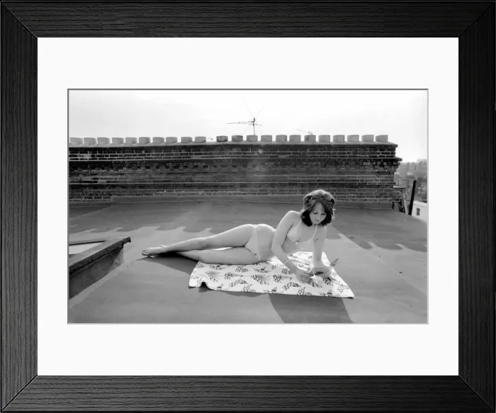 Framed Print : A model wearing a bikini as she subathes on a rooftop on Kings Road in Chelsea, London Framed Print : A model wearing a bikini as she subathes on a rooftop on Kings Road in Chelsea, London