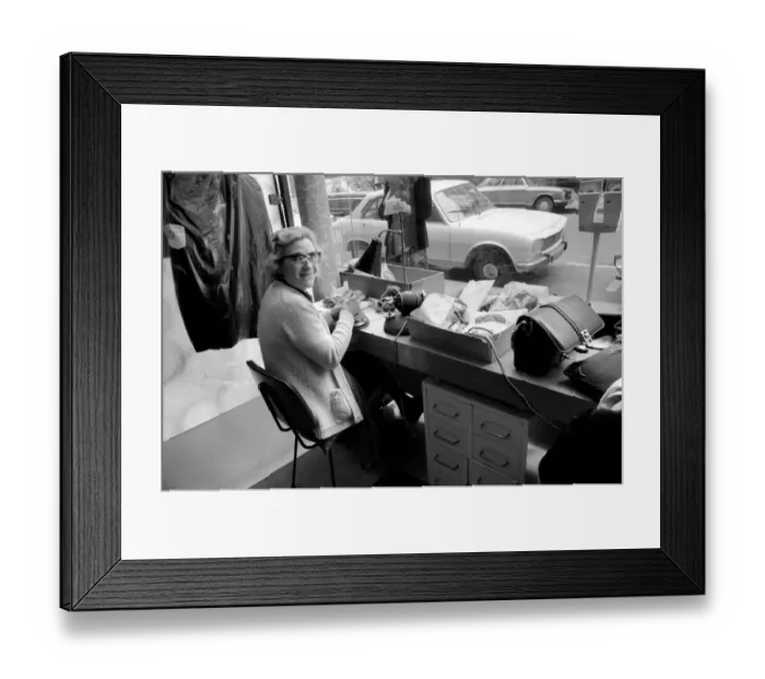 Framed Print : An old woman mending ladders in tights at a shop near the Champs Elysees in Paris