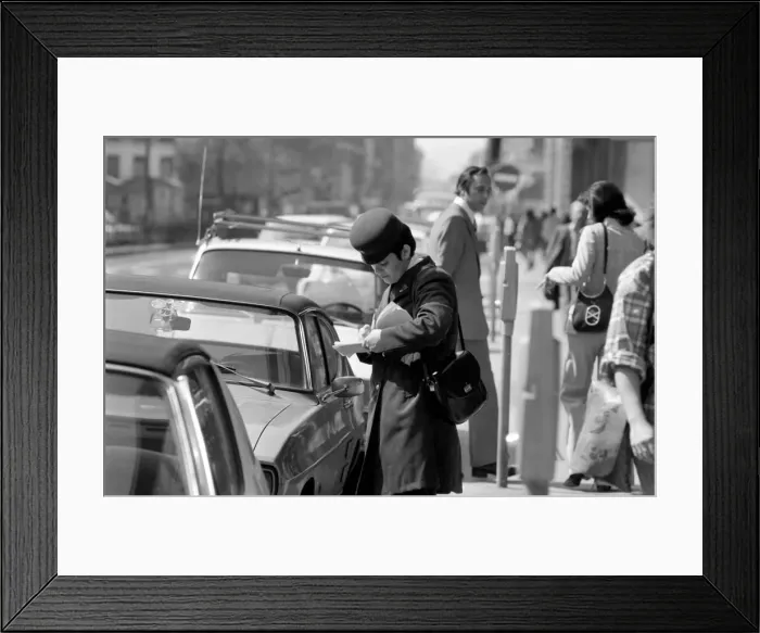 Framed Print : A traffic warden putting a ticket on a car without a tocket during her patrol Framed Print : A traffic warden putting a ticket on a car without a tocket during her patrol