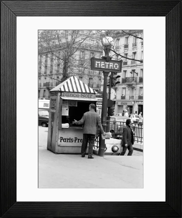 Framed Print : A Morning newspaper reader picks up his paper from a kiosk in the 15th district of Paris