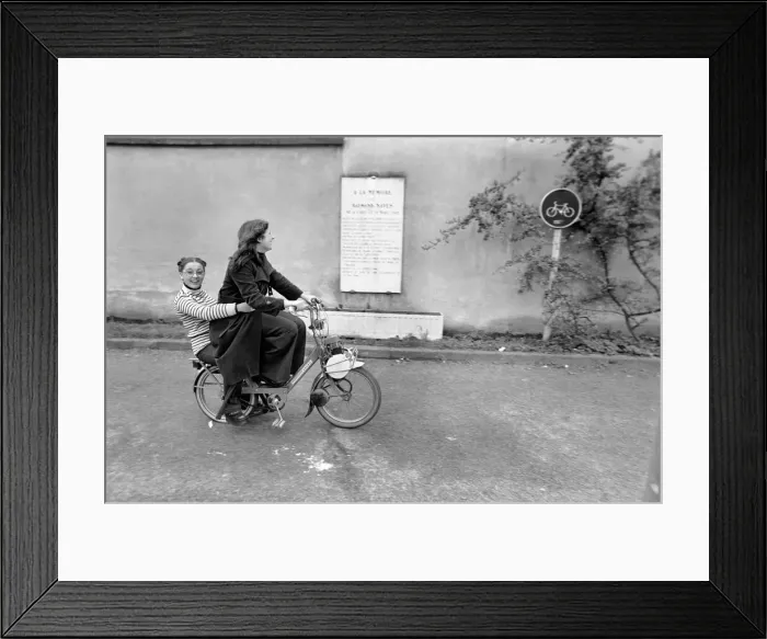 Framed Print : Two women riding on an electric bicycle. April 1975 75-2072-021 Framed Print : Two women riding on an electric bicycle. April 1975 75-2072-021