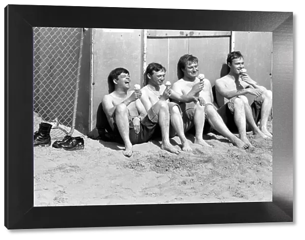 Four men sitting enjoying an ice cream in the hot weather at Margate Beach