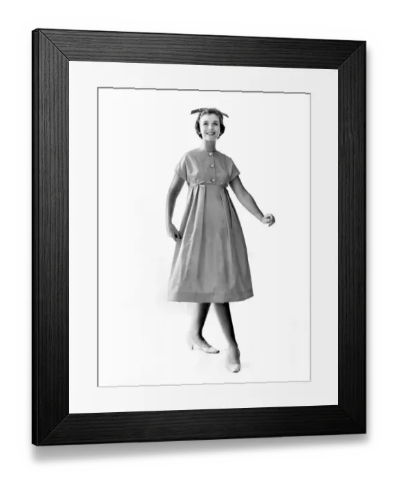 Framed Print : Reveille Fashions 1958: Ann Cave modeling a button summer dress. October 1958 P006896