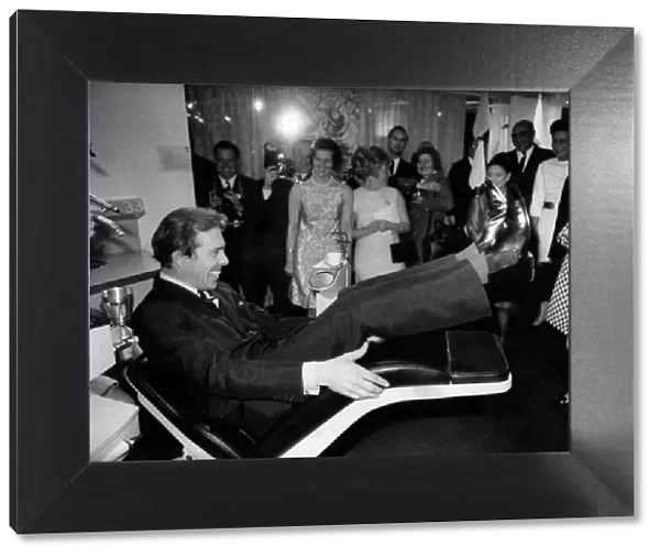 Lord Snowdon trying out the motorised reclining dentist chair at the exibition