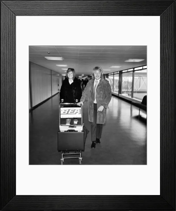 Framed Print : Singer Cilla Black pictured at Heathrow airport with her husband Bobby Framed Print : Singer Cilla Black pictured at Heathrow airport with her husband Bobby