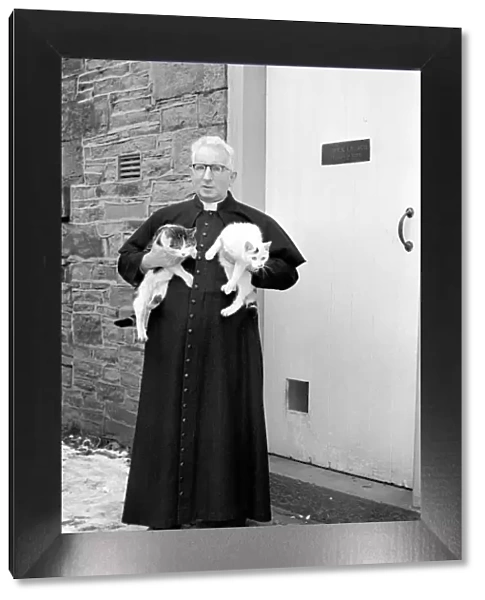 The parish priest seen here gathering up his pet cats February 1970 70-1627-005
