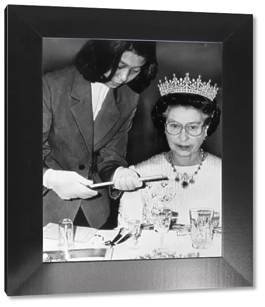 The Queen in China at a banquet in Peking. Being handed chopsticks to eat sea slugs with