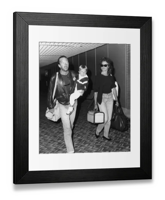 Framed Print : Eric Clapton singer songwriter and girlfriend Lori Del Santo walk through airport with