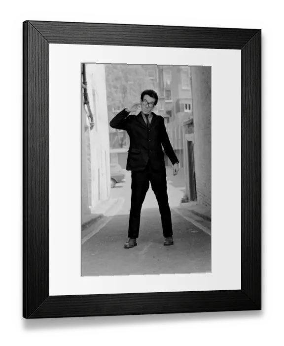 Framed Print : Elvis Costello, the newest sensation on the music scene, standing in small street Framed Print : Elvis Costello, the newest sensation on the music scene, standing in small street