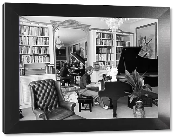 Elton John in his new £50, 000 mansion in Camberley, Surrey playing his piano