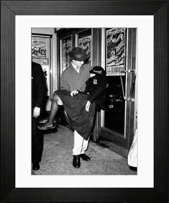 Framed Print : A Female Beatles Fan is carried out at a concert in Exeter. 14th November 1963 Framed Print : A Female Beatles Fan is carried out at a concert in Exeter. 14th November 1963