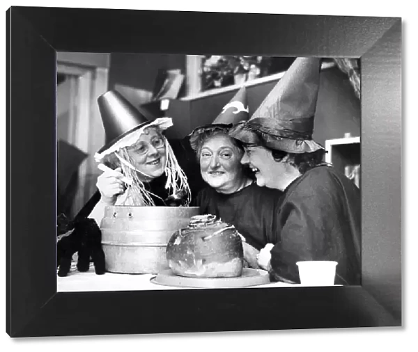 Mixing up a strong brew in their cauldron, three witches at the Halloween party held by