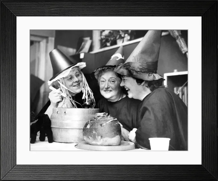Framed Print : Mixing up a strong brew in their cauldron, three witches at the Halloween party held by Framed Print : Mixing up a strong brew in their cauldron, three witches at the Halloween party held by