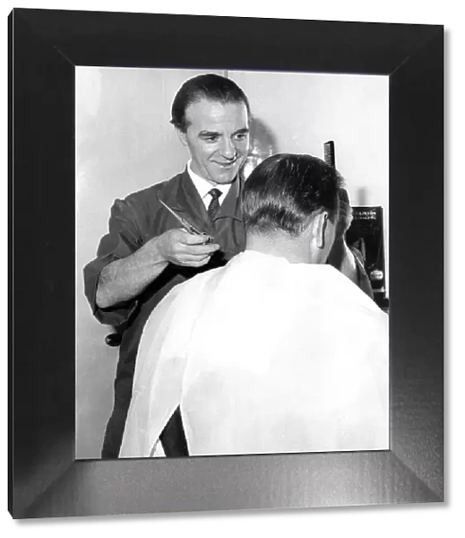 An old fashioned barber cutting a mans hair in February 1966