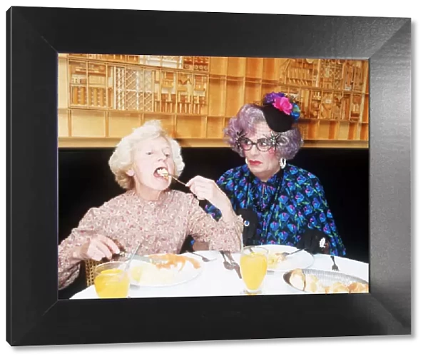 Barry Humphries as Dame Edna Everage glasses hat with Madge open mouth eating in La