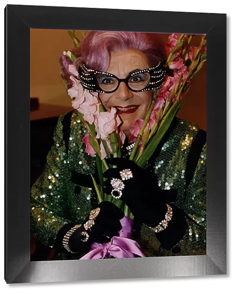 Dame Edna Everage Barry Humphries gladioli gladioluses purple hair large glasses black