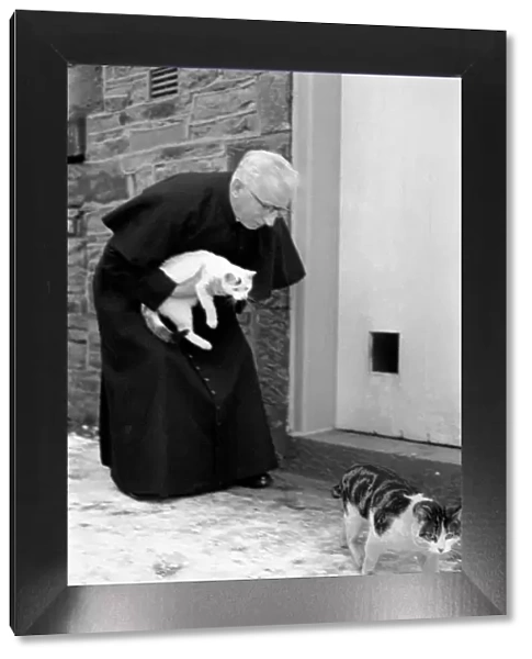 The parish priest seen here gathering up his pet cats February 1970 70-1627-001