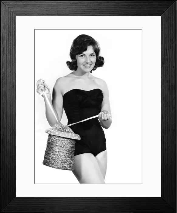 Framed Print : Reveille Fashions: Diana Lovell wearing a one piece swimming costume holding a rope beach Framed Print : Reveille Fashions: Diana Lovell wearing a one piece swimming costume holding a rope beach