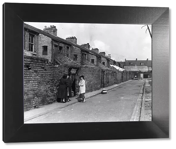 Derelict housing in an area of Newcastle - A group of women gossip in the back lane