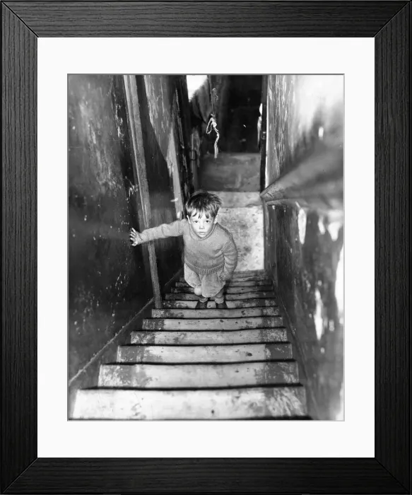 Framed Print : The Interior of slum housing in an area of Newcastle - A dirty child climbing the stairs