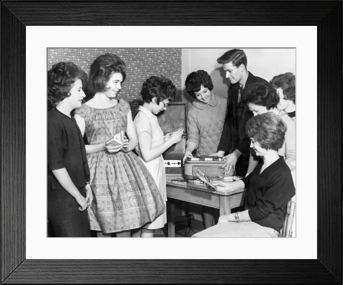 Framed Print : Teenagers crowd around the tape and record player at their local youth club