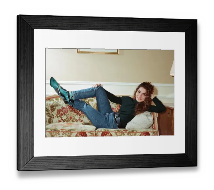 Framed Print : Pop singer Gloria Estefan poses lying down on a sofa in her hotel room on a visit to Framed Print : Pop singer Gloria Estefan poses lying down on a sofa in her hotel room on a visit to