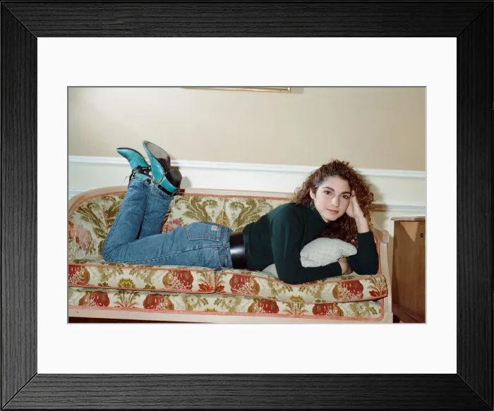Framed Print : Pop singer Gloria Estefan poses lying down on a sofa in her hotel room on a visit to Framed Print : Pop singer Gloria Estefan poses lying down on a sofa in her hotel room on a visit to