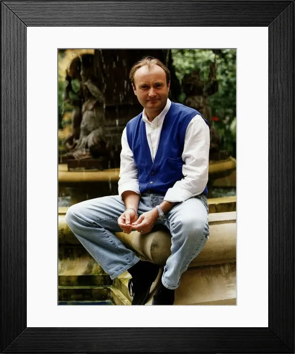 Framed Print : Phil Collins singer poses for a picture while sitting on the edge of a water fountain
