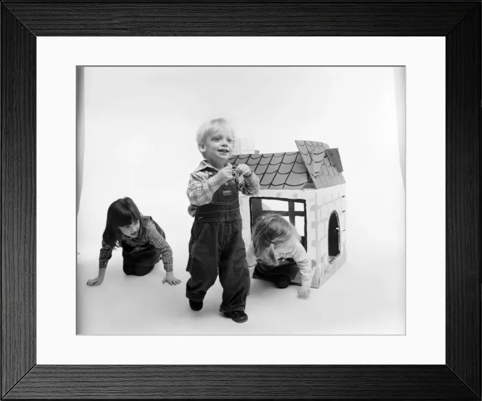Framed Print : Toys: Children playing with a Wendy house made out of cardboard Framed Print : Toys: Children playing with a Wendy house made out of cardboard