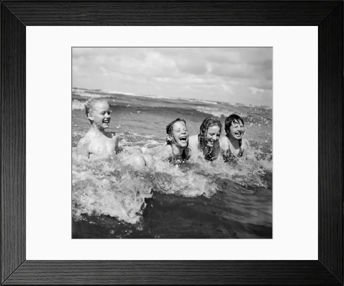 Framed Print : Four children enjoy a swim in the sea at Blackpool beach in the summer holidays Framed Print : Four children enjoy a swim in the sea at Blackpool beach in the summer holidays