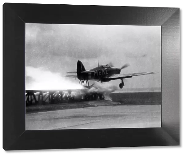 A Royal Air Force Hawker Hurricane is catapaulted down a launching ramp on the bow of a