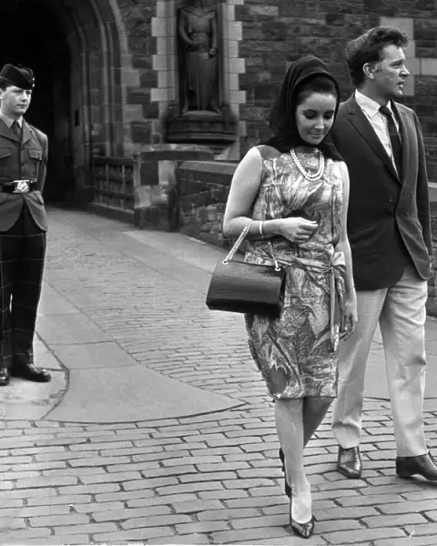 Actress Elizabeth Taylor with her husband Richard Burton walk away disappointed after not