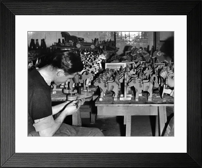 Framed Print : J. McCarthay of the RAF puts the finishing touches to a toy boat