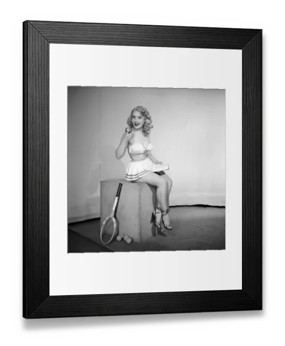 Framed Print : Anyone for tennis? Woman wearing bra, skirt holding tennis racket. 1959