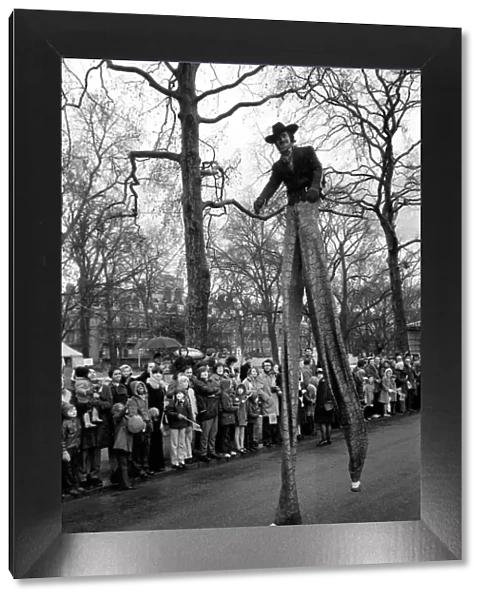 A stilt walker taking part in the Easter parade, Battersea Park. March 1975 75-1706-009