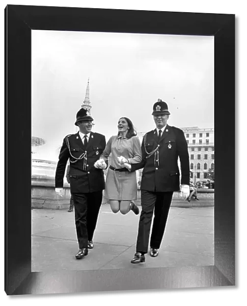 Woman being held up by two policemen in Trafalgar Square, London. October 1969 Z10351