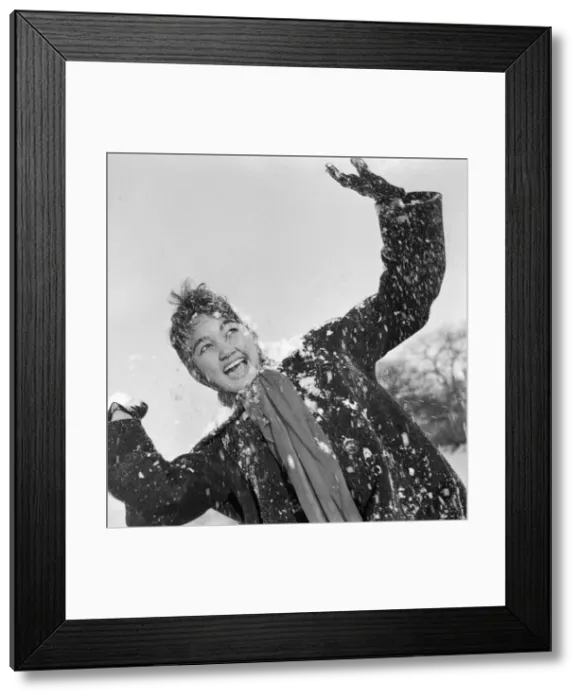 Framed Print : Philippine dancers have a snowball fight in London. One of the woman throwing