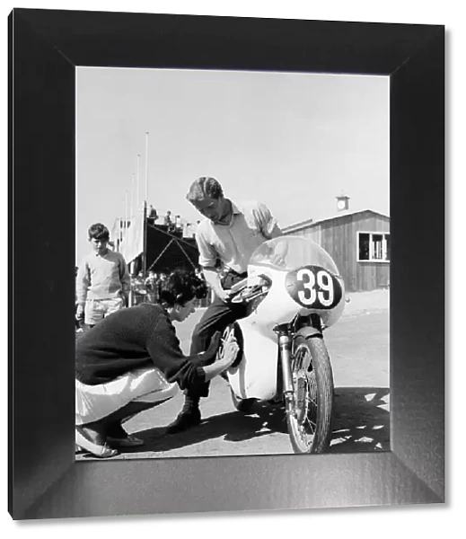 Mike Hailwood with girlfriend Pauline Nash helping him put on his race numbers 5th