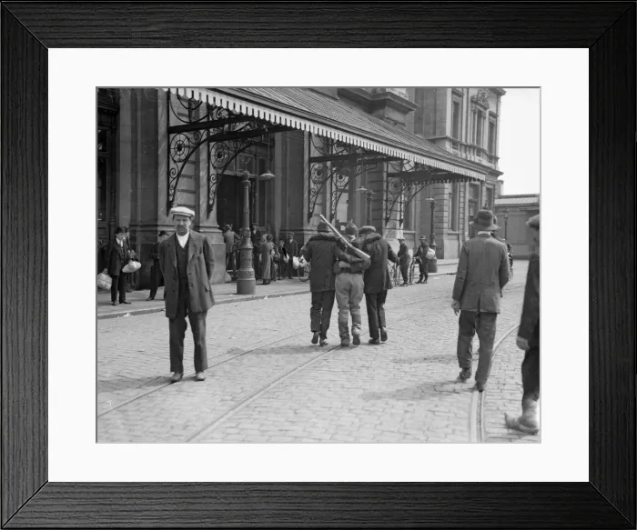 Framed Print : Two civilians help a wounded Belgian soldier to the railway station at Louvain Framed Print : Two civilians help a wounded Belgian soldier to the railway station at Louvain