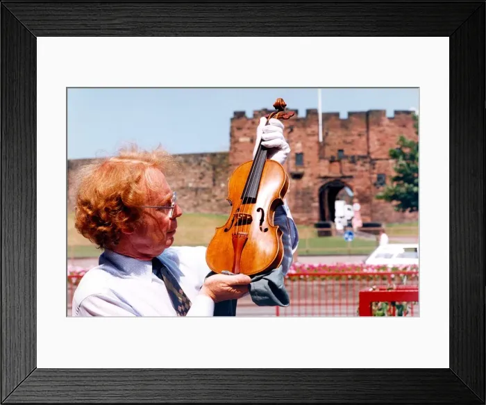 Framed Print : Carlisles Tullie House Museum curator David Clark with a violin dated from 1565
