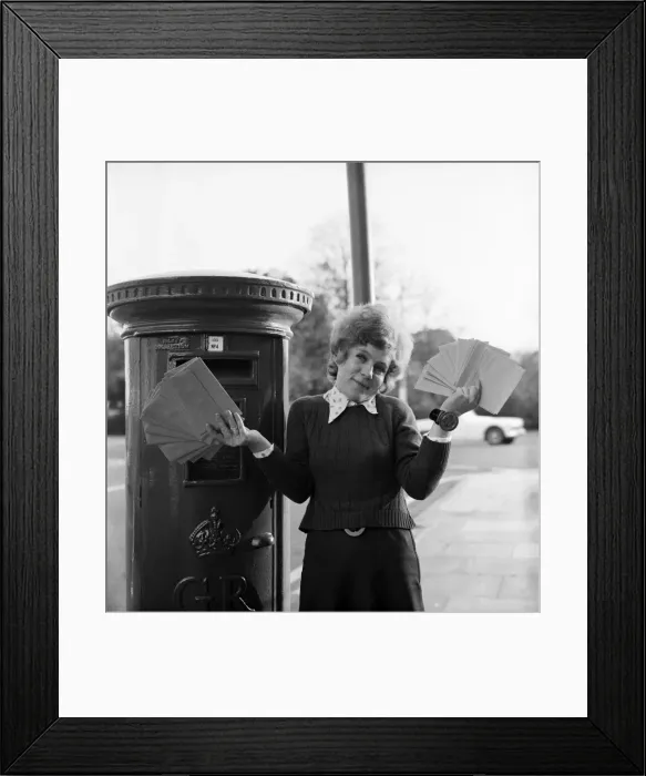 Framed Print : Communications: Woman holding a large collection of letters as she stand by a Royal Mail