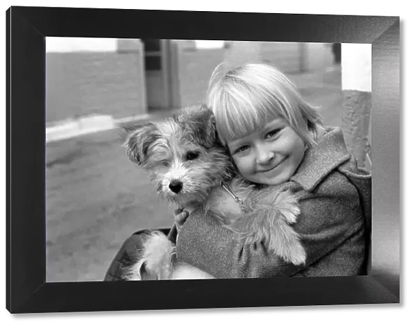 Cute children and Animals: Young girl holding her puppy dog. January 1980 80-00007-003