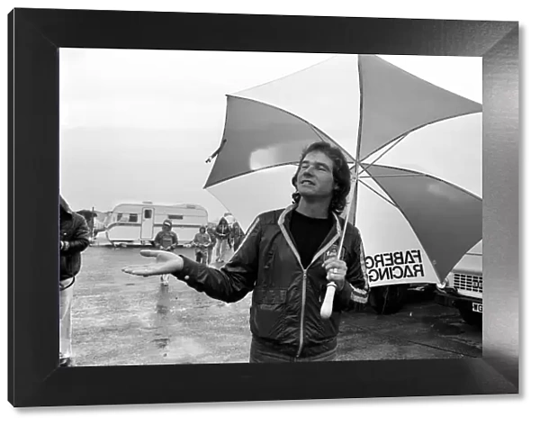 John Player British Grand Prix, Silverstone. Barry Sheene with umbrella in the rain