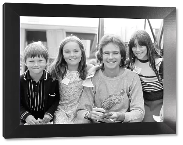 Barry Sheene signs autographs for three young children who broke through the security to