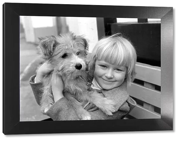 Cute children and Animals: Young girl holding her puppy dog. January 1980 80-00007-002