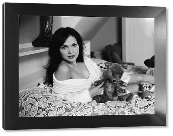 Actress Madeline Smith poses on the bed with her teddy bears. 2nd November 1973